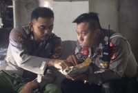 Dua Polisi Nikmati Nasi Bungkus Bersama di Dermaga Bakauheni Saat Hujan Deras