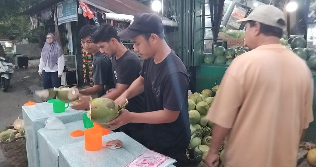 Muhammad siddiq beserta teman" nya sedang melayani pelanggan yang membeli air kelapa di, Jl. AMD, Banda Aceh. (TubinNews/Nurul Azkia)