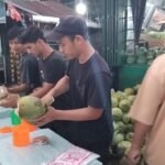 Muhammad siddiq beserta teman" nya sedang melayani pelanggan yang membeli air kelapa di, Jl. AMD, Banda Aceh. (TubinNews/Nurul Azkia)