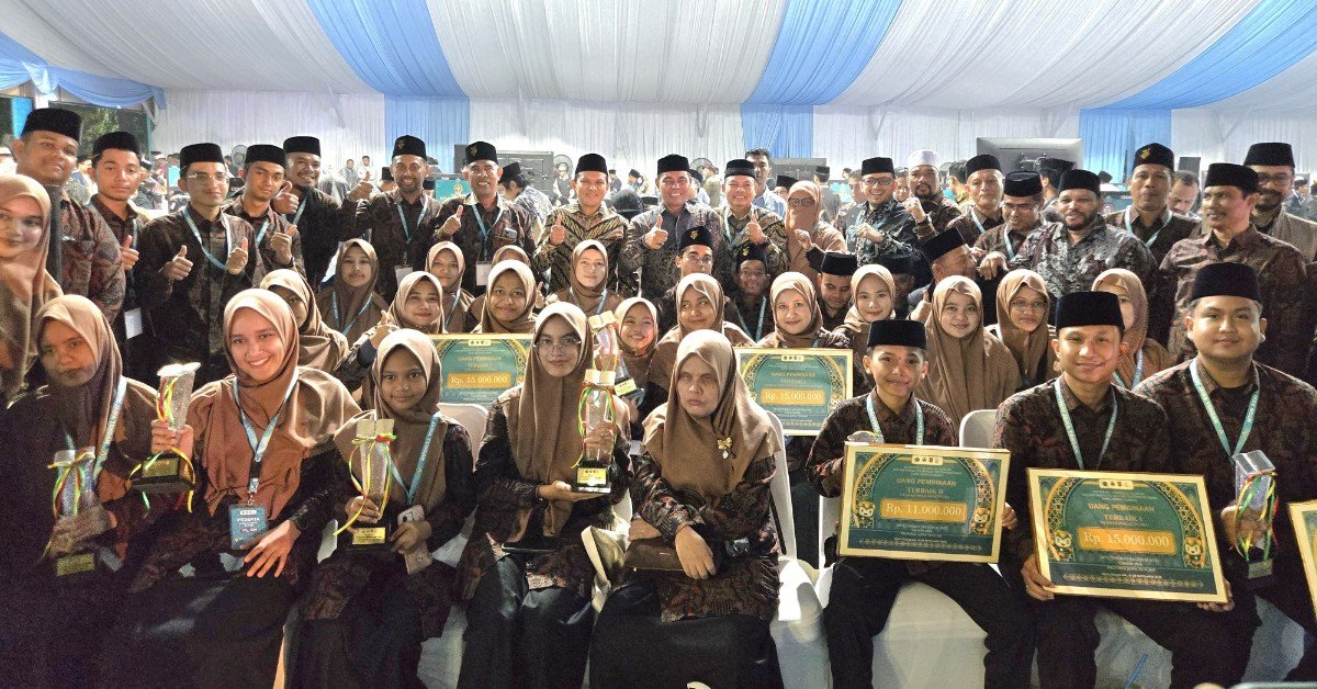 Kafilah Aceh berfoto bersama dengan piala serta papan simbolis juara. (Dok. Ist)