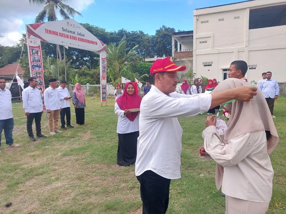 Ketua PMI Aceh Besar, Syukri A. Jalil, mengalungkan tanda pengenal peserta saat membuka orientasi PMR tingkat Wira dan Madya se-Aceh Besar. (Dok. PMI Aceh Besar)