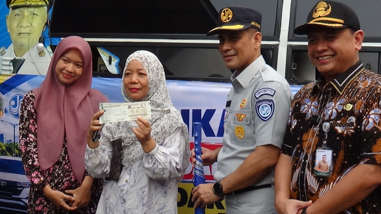Direktur Lalu Lintas Polda Sumut, Kombes Pol Achmad Fauzi Dalimunthe (kanan Abu-abu) dan Kepala Bapenda Sumut, Sutan Tolang Lubis (kanan batik) foto bersama warga yang membayar pajak kendaraan. (Dok. Ist)