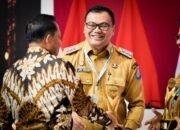 Bupati Deli Serdang, Asri Ludin Tambunan menerima piala penghargaan langsung dari Mendagri, Tito Karnavian. (Dok. Diskominfostan Deli Serdang)
