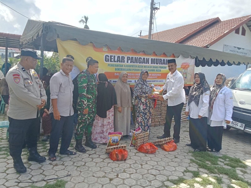 Camat Kuta Baro, Zahrul Fuadi menyerahkan paket sembako Gerakan Pangan Murah kepada masyarakat secara simbolis di halaman Meunasah Gampong Lamceu. (Dok. Humas Pemkab Aceh Besar)