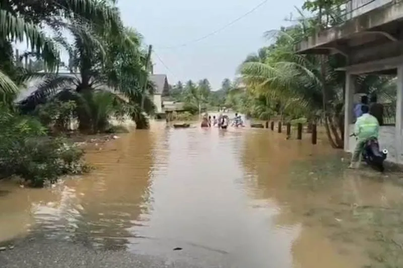 Warga melintasi ruas jalan terendam banjir di Aceh Selatan, Minggu (25/10/2026). (Dok. BPBD Aceh Selatan)