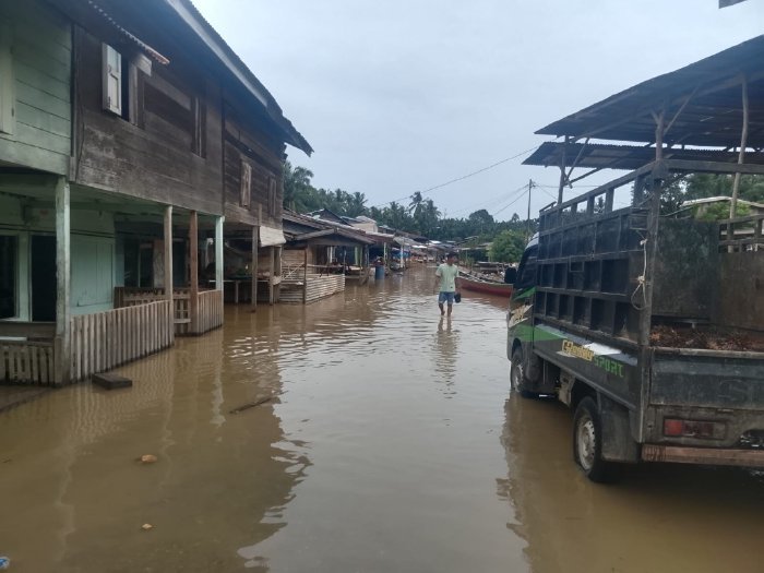 Seorang warga sedang melintasi banjir. (Dok. BPBD Subulussalam)